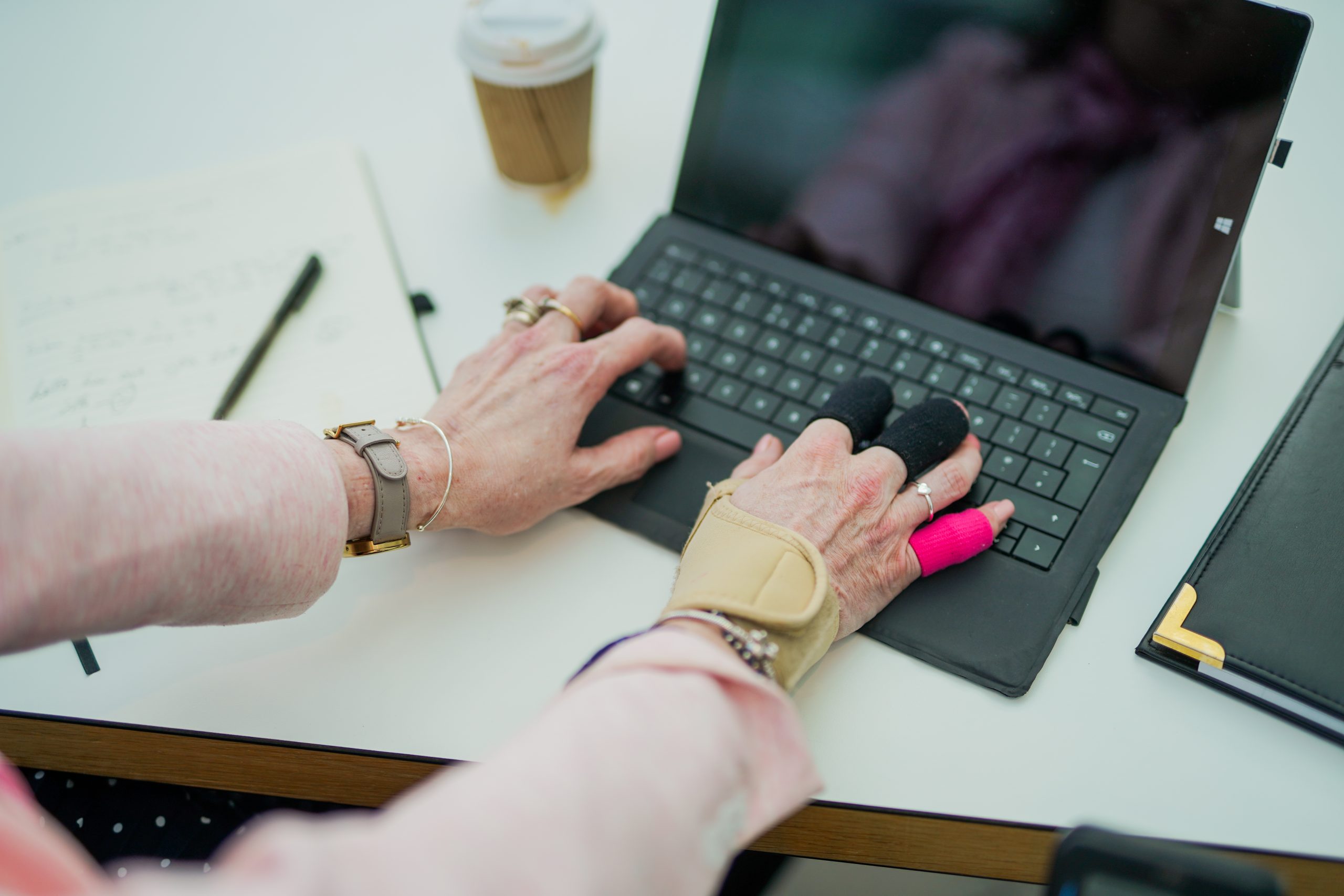 A wheelchair user using a laptop in an office